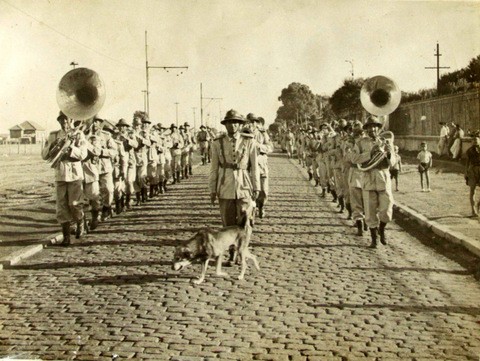 Músicos da Banda de Música da Brigada Militar tocando instrumentos musicais em duas filas
