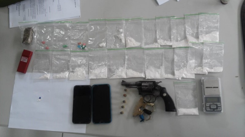 várias porções de drogas, arma, balança de precisão, celulares