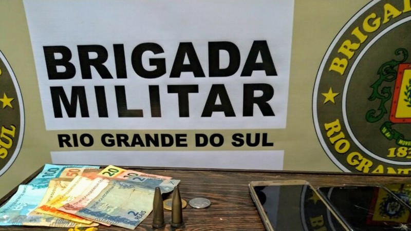 Dinheiro apreendido à frente de banner da Brigada Militar