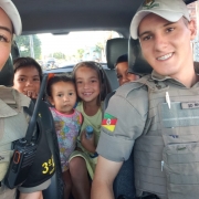 policias militares com as crianças dentro da viatura policial
