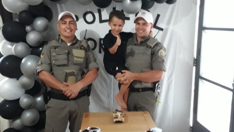 menino aniversariante no colo do policial