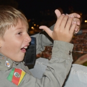 A imagem mostra um menino fardado aplaudindo o jogo