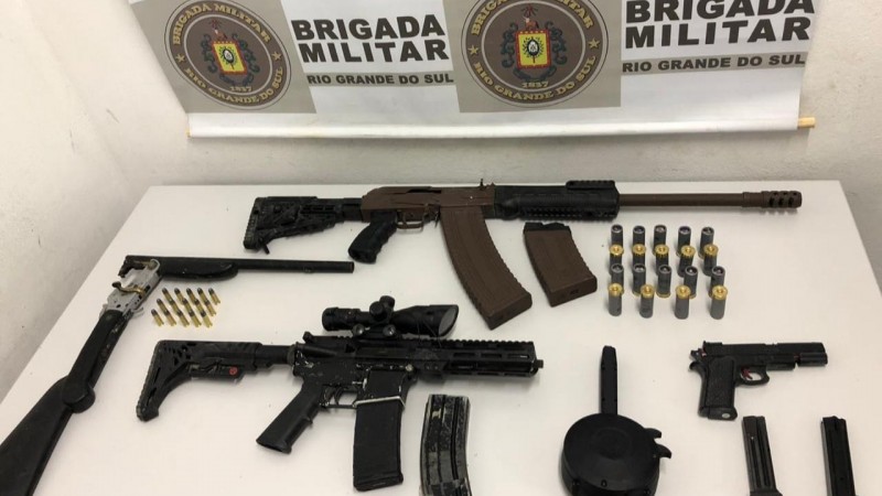 A imagem mostra armas e muni&ccedil;&otilde;es sobre uma mesa