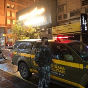 policial parado proximo a viatura no centro