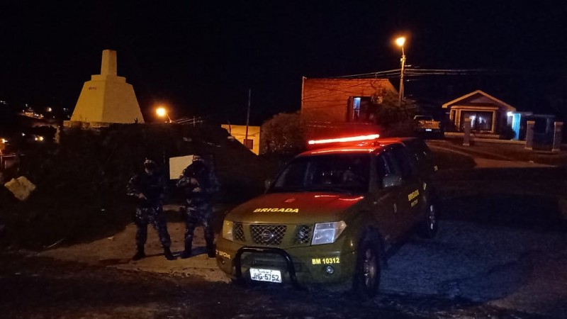 policiais parados prox ao marco da divisa