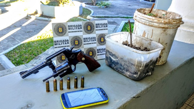 arma de fogo e pés de maconha