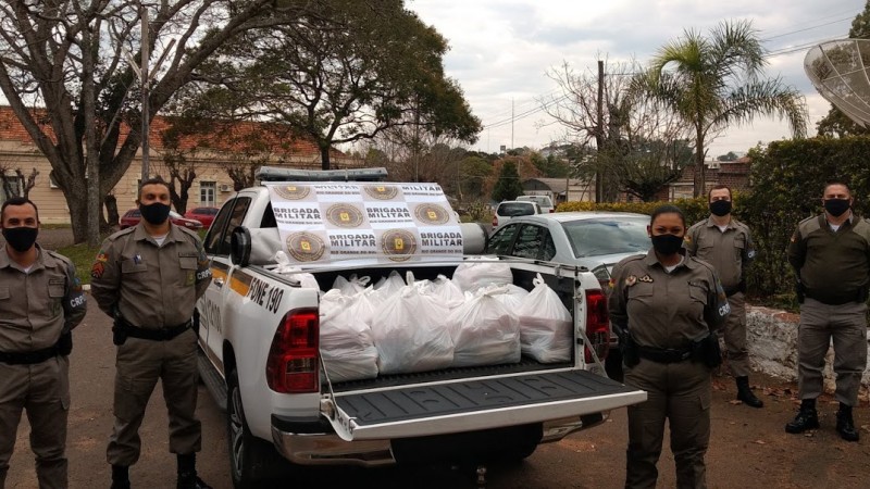 policiais na viatura com as cestas básicas