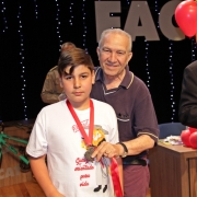 Prof Edmar entregando medalha a aluno Proerd
