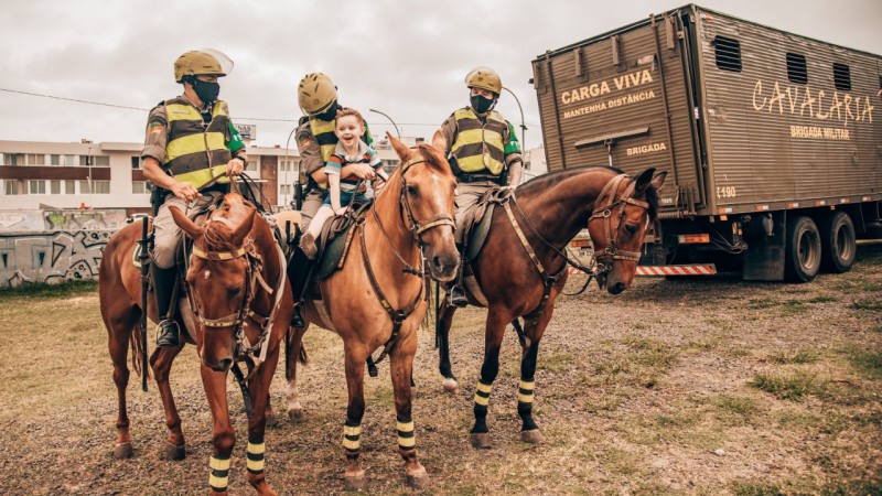 Menino autista Pedro Antônio interagindo com os cavalos da nossa BM