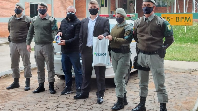 Policiais Militares recebendo a doação de um telefone celular para patrulha maria da penha do município de Cachoeira do Sul.
