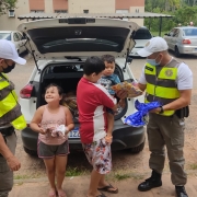 Criança felizes recebendo presente de policiais militares