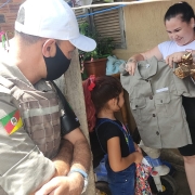 Criança feliz com a farda que ganhou da polícia militar