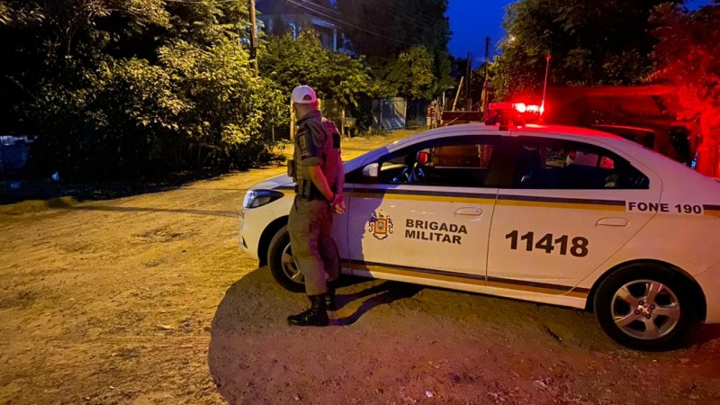 Policial Militar parado ao lado de viatura