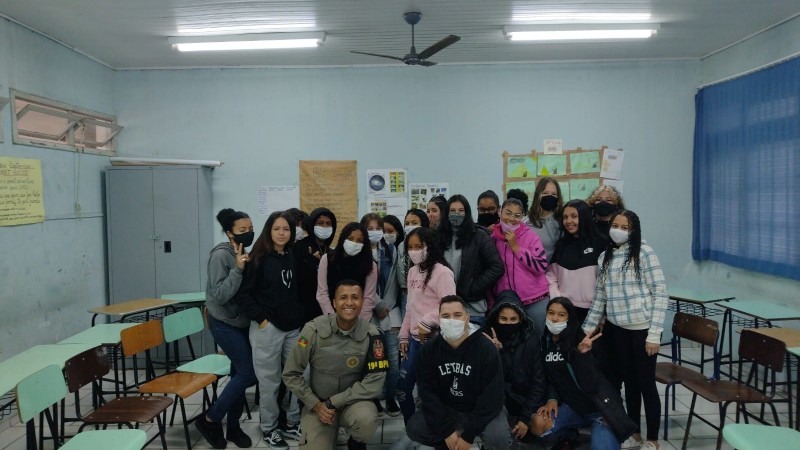 Fotografia de alunos com membro da Patrulha Escolar 19bpm