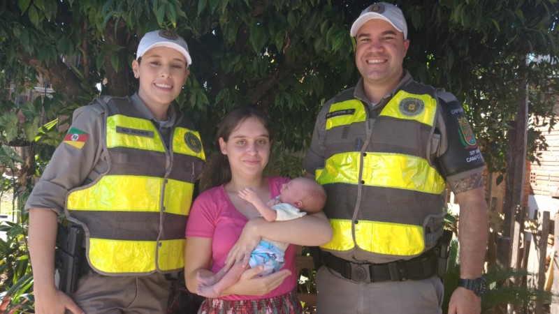 Policiais, mãe e bebê posando para foto.