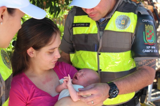 Policiais com bebê que fora salvo e mãe