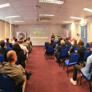 Convidados do evento, sentados assistindo a apresentação do Laboratório.
