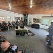 Grupo de Militares do Choque sentados em uma sala, assistindo palestra.