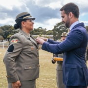 Em campo aberto, o governador Eduardo Leite coloca medalha no peito de formanda