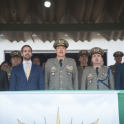 Foto mostra o secretário de Segurança Pública, Sandro Caron, o governador Eduardo Leite e o comandante-geral da BM, coronel Cláudio Feoli, perfilados em palanque