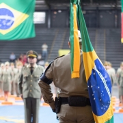 Foto mostra soldado carregando bandeira do Brasil dentro de ginásio
