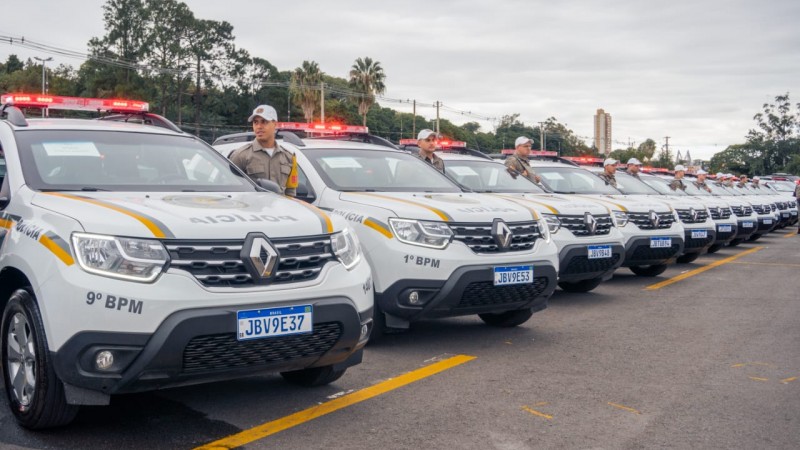 Imagem mostra vários Renault/Duster enfileirados em um estacionamento a céu aberto com policiais perfilados ao lado de cada viatura