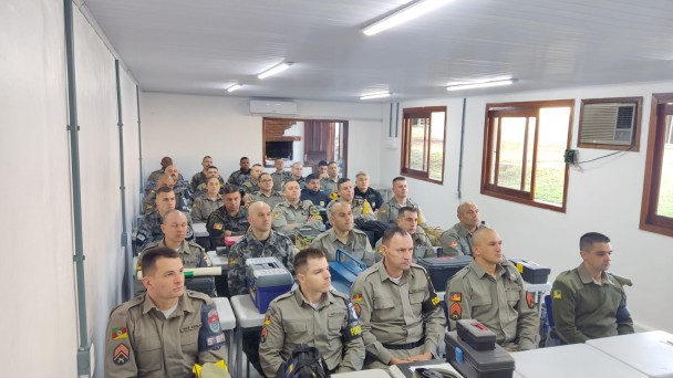Imagem mostra sala de aula lotada com efetivo da Brigada Militar sentado em suas mesas de alunos