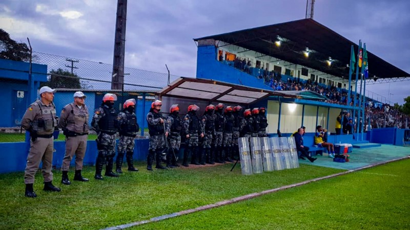 Comandante da operação e equipe da Força Tática no campo de futebol