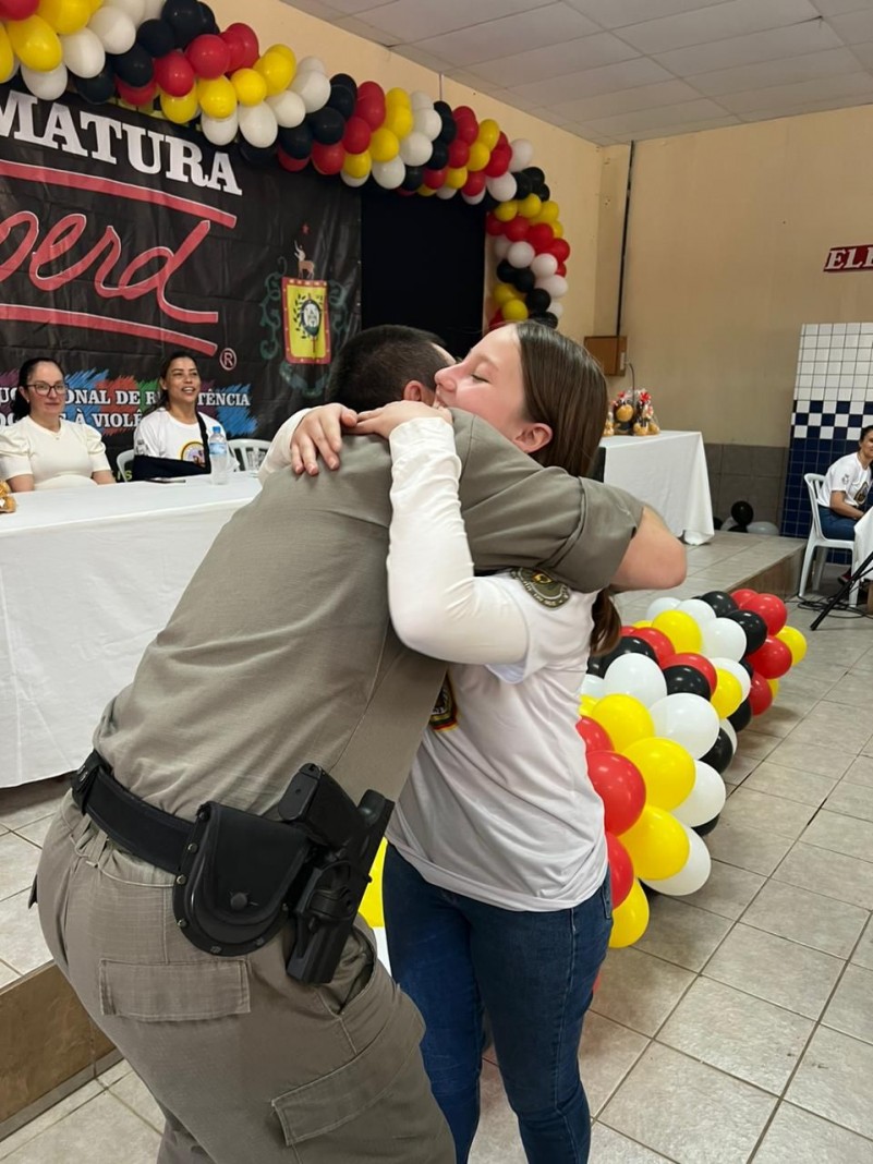 Soldado Julian abraçando uma das alunas premiadas durante o semestre