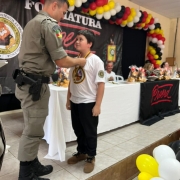 Capitão Stona colocando medalha do programa em um dos alunos