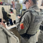 Na imagem: celulares ao fundo e, mais centralizada, a militar consultando os IMEI's dos aparelhos