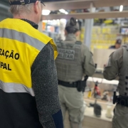 Na imagem: celulares ao fundo e, mais centralizada, a militar consultando os IMEI's dos aparelhos e um agente da Fiscalização Municipal 