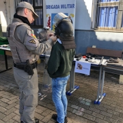 Policiais militares interagindo com estudante