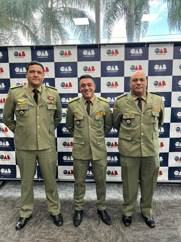 Perfilados, estão três coronéis da Brigada Militar. Na parte de trás, está um banner da OAB