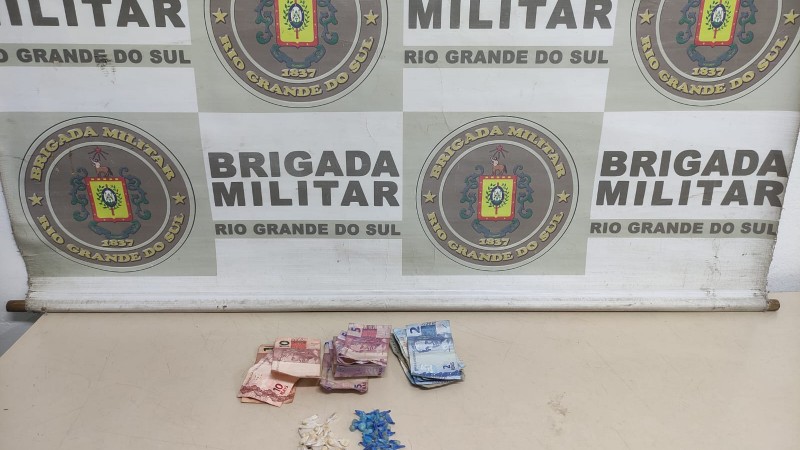 A imagem mostra o banner da Brigada Militar, ao fundo, nas cores bege e branco. Em alguns quadrados, o brasão da unidade que é composto por um escudo na cor azul, tendo desenhos delimitadores na cor preta (nigrum), dois ramos de louros na cor verde (sinopla), acima do castelo uma estrela de cinco pontas na cor ouro (amarelo ouro), um listel em forma de laço com contornos na cor preta (nigrum) e no fundo totalmente branco, sendo o mais próximo do castelo contendo o acrônimo da escola, seguido do acrônimo da unidade da federação – APM - RS - em preta (nigrum). e, em outro, escrito "Brigada Militar - Rio Grande do Sul" com dois dinheiro e porções de entorpecentes