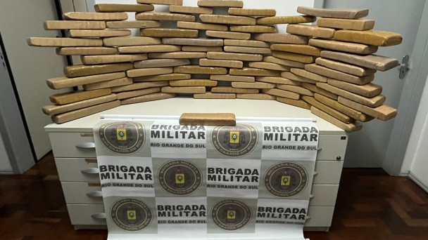 90 tijolos de maconha expostos sobre a mesa.