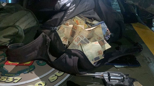 Imagem mostra mochila aberta com o dinheiro roubado durante o assalto a uma agência bancária