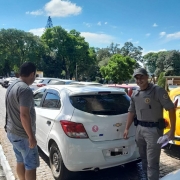 Na foto, um policial militar, integrante da Patrulha Maria da Penha, colocou um adesivo em um veículo, na ação de prevenção à violência contra as mulheres.