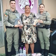 policiais militares recebendo um mimo pela participação no evento.