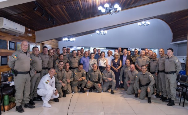 Foto mostra pessoas reunidas posando para a foto em um auditório