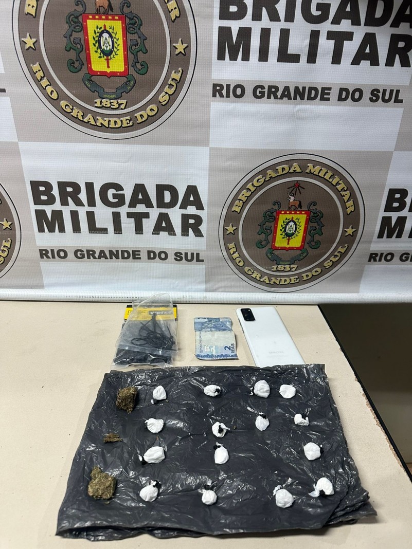 Porções de maconha apreendidas em cima de uma mesa e atrás, um banner da Instituição