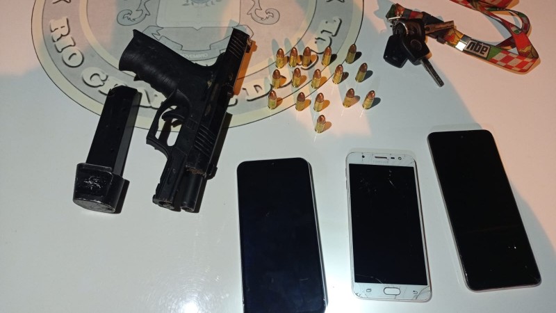 Uma pistola calibre nove milímetros, um carregador, dezesseis munições e três celulares apreendidos