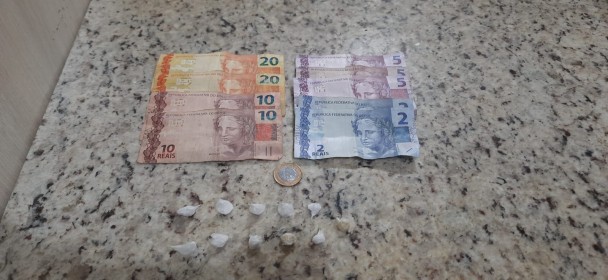 Nove porções de cocaína e duas pedras de crack em cima de uma mesa