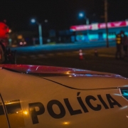 Viatura policial militar e ao fundo um policial militar