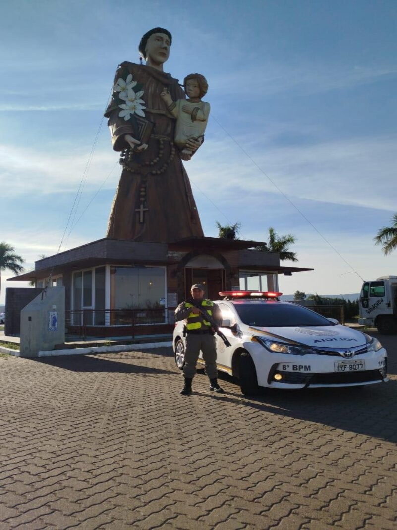 Policial militar em frente a uma estátua de Santo Antônio da Patrulha