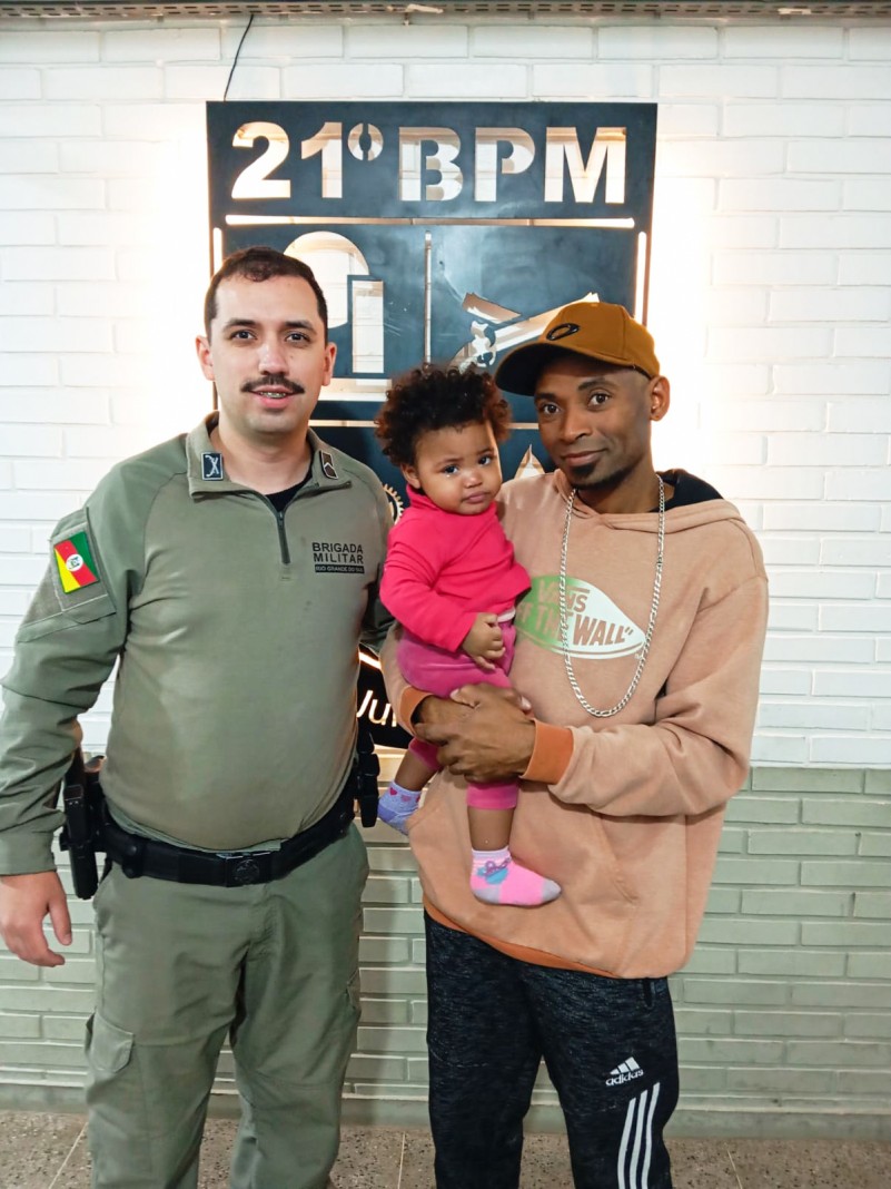 Policial militar com a criança que havia se engasgado e o pai