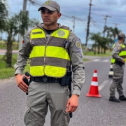 Um aluno-soldado mais a frente e, ao fundo, um aluno-soldado abordando veículo