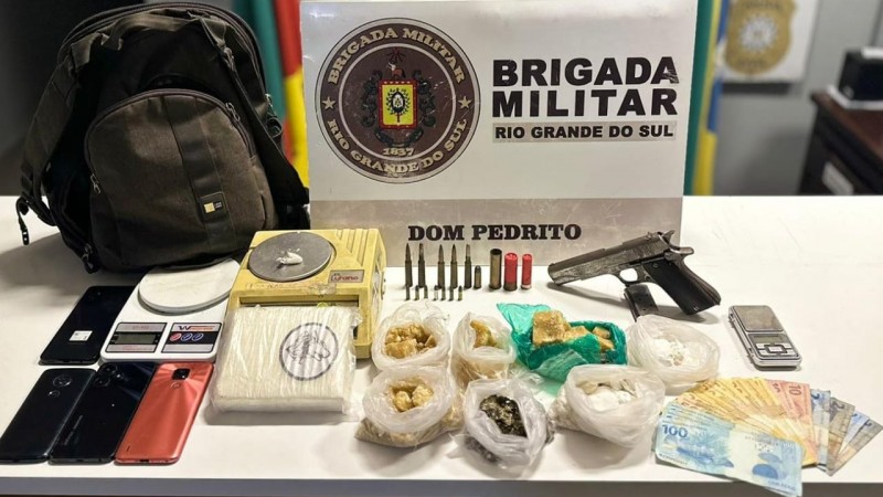 Material apreendido   em cima de uma mesa, diversos tipos de drogas, muni&ccedil;&otilde;es, quatro celulares, uma arma de fogo, balan&ccedil;a de precis&atilde;o