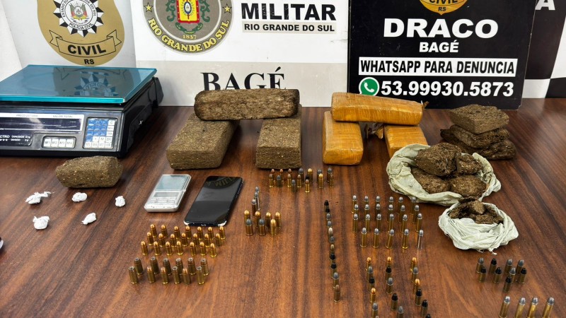 Diversos entorpecentes em cima de mesa, juntamente com munições de armas de diversos calibres, dois celulares e uma balança de precisão