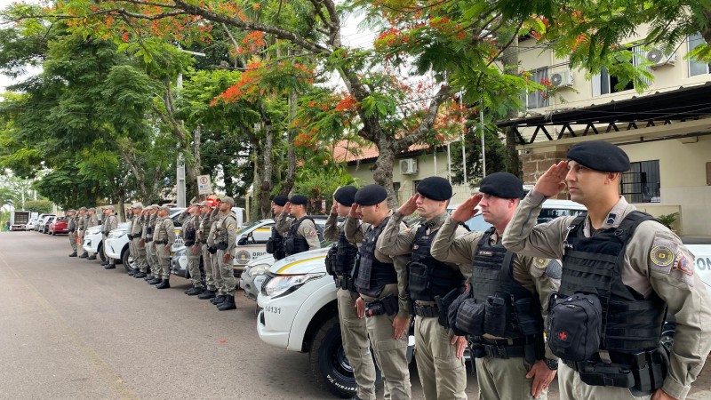 Policiais militares prestando continência.